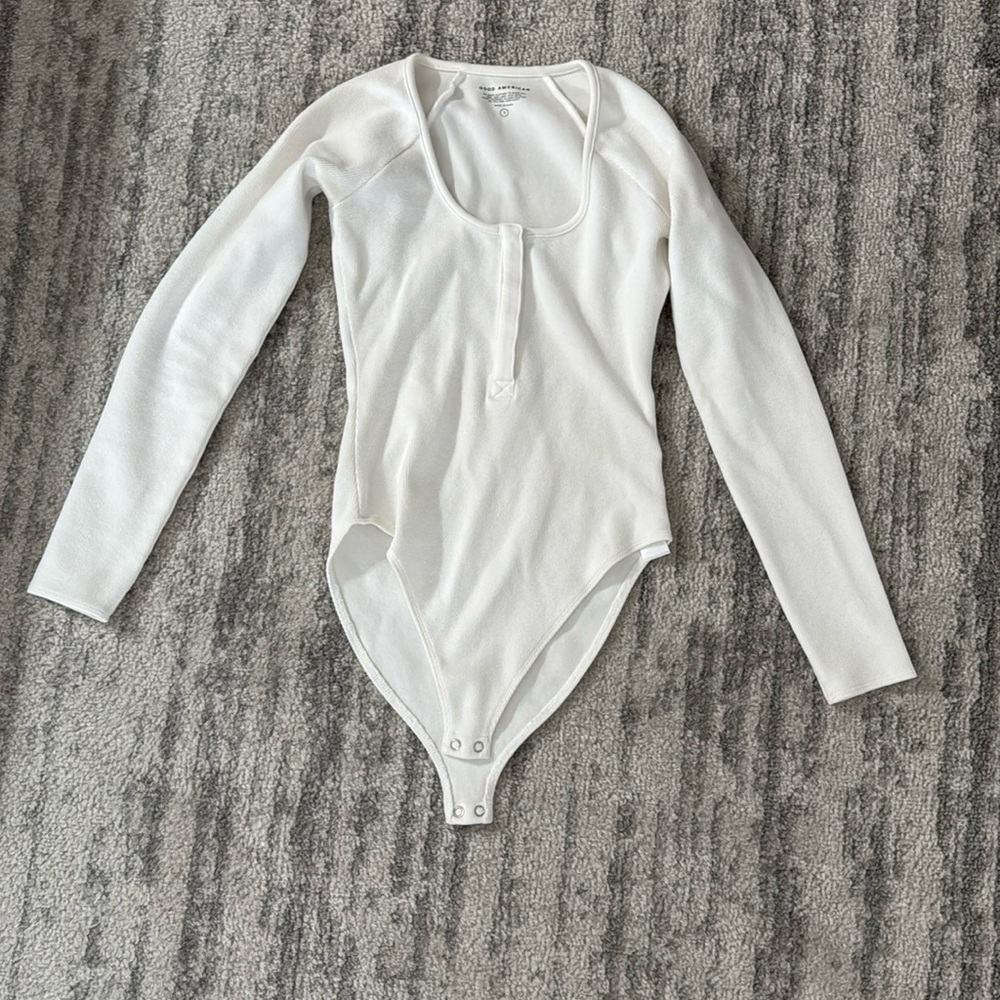 White long sleeve body suit with snip button details in middle of chest